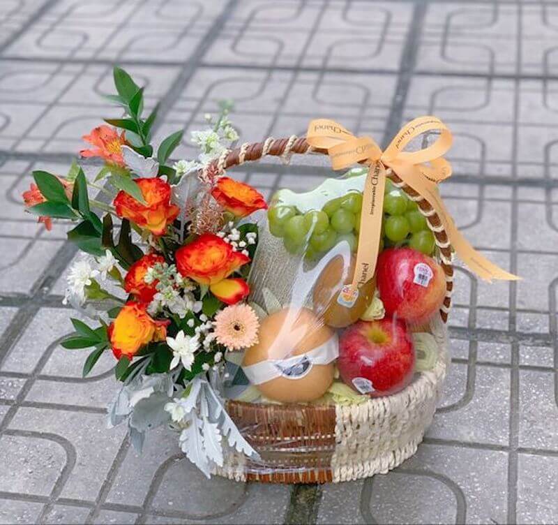 Giỏ quà trái cây kính viếng với hoa và nơ.